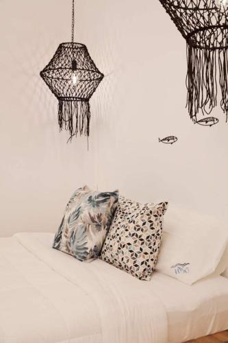 a bed with a pillow and a chandelier at Megali Ammos House in Megali Ammos