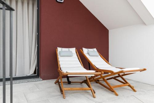 two lounge chairs sitting next to a wall at Botica Guesthouse in Espinho