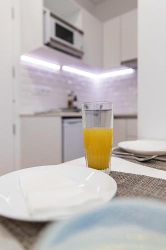 a glass of orange juice sitting on top of a counter at Botica Guesthouse in Espinho