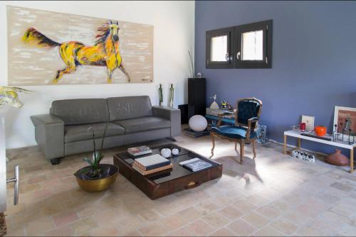 a living room with a couch and a painting of a horse at Chambre Zen King Size in Pierrelatte
