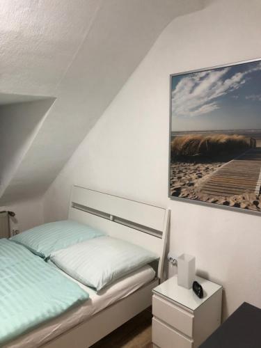 een slaapkamer met een bed en een foto aan de muur bij Wohnen auf Zeit in Duisburg
