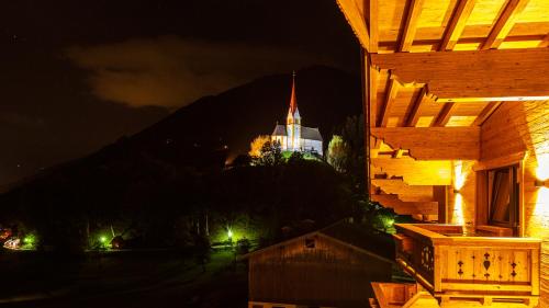 a view of a building at night with a mountain at Hotel Garni Romantik in Fügen