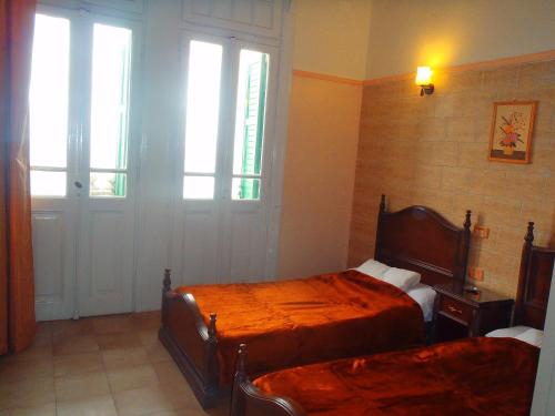 1 Schlafzimmer mit 2 Betten und 2 Fenstern in der Unterkunft Fouad Hotel in Alexandria
