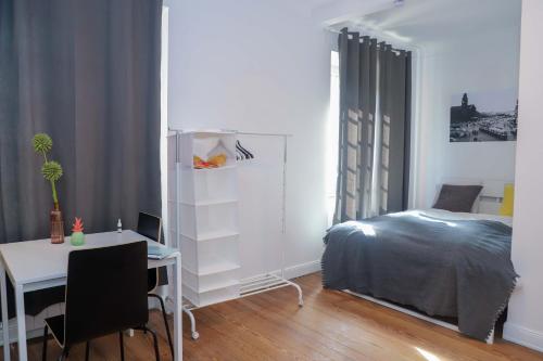a bedroom with a bed and a desk and a table at The red house in Luxembourg