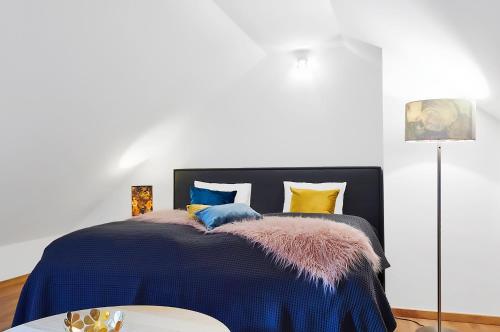 克維爾達的住宿－Kvilda Apartments，一间卧室配有一张带蓝色棉被的床和一张桌子