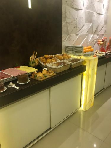 a buffet line with many different types of food at Hotel Ibicui in Rosário do Sul