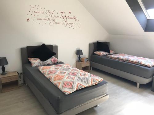 a bedroom with two beds and a bed with a comforter at Ferienwohnung im Wonnegau Portugieser-Suite in Flörsheim-Dalsheim