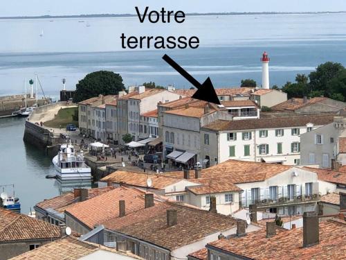 a view of a town with a white lighthouse at La terrasse sur les toits in Saint-Martin-de-Ré