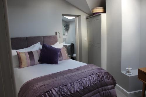 - une chambre avec un grand lit et des oreillers violets dans l'établissement The Old Post Office pretty village 20min from York, à York