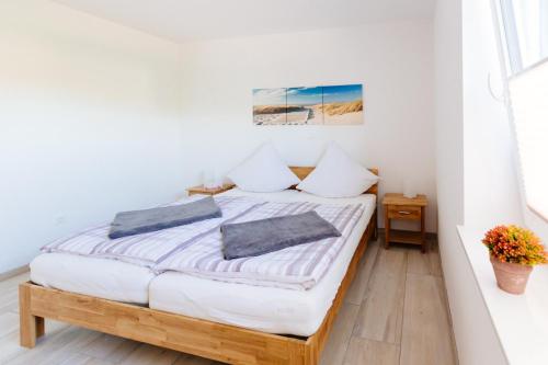 a bedroom with a bed with white walls at Weserrobbe in Bremerhaven