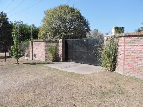 una cerca con una puerta negra junto a una pared de ladrillo en Cerros de Salta en Salta