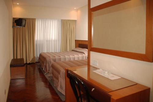 a hotel room with a bed and a desk with a mirror at Hotel Napoleón in Buenos Aires