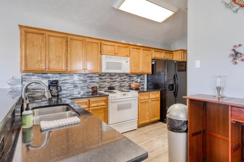 a kitchen with wooden cabinets and a sink and refrigerator at Tranquil Seas in Saint Joe Beach