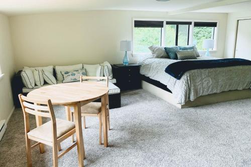 a bedroom with a bed and a table and a couch at The Tides Retreat in Gig Harbor