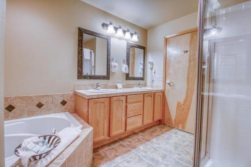 a bathroom with a tub and a sink and a shower at Icicle Village Resort 402: Juniper Studio in Leavenworth