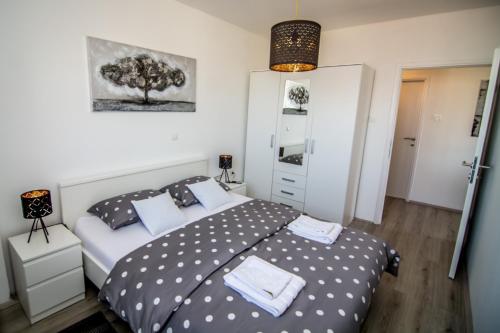 a bedroom with a bed and a tree on the wall at Sky in Slavonski Brod