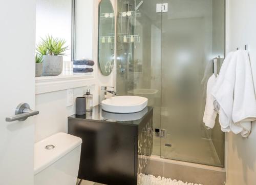a bathroom with a sink and a glass shower at Absolute Beach in Mount Maunganui