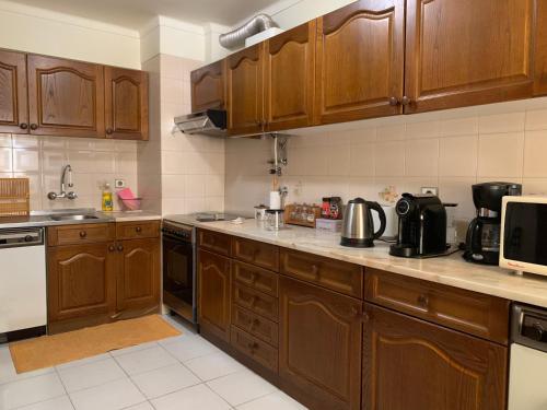 a large kitchen with wooden cabinets and appliances at Casa vista Azul in Sesimbra