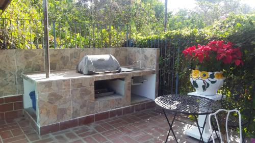 a patio with a grill and a vase with red flowers at Villa San Antonio - El Valle de Anton in El Valle