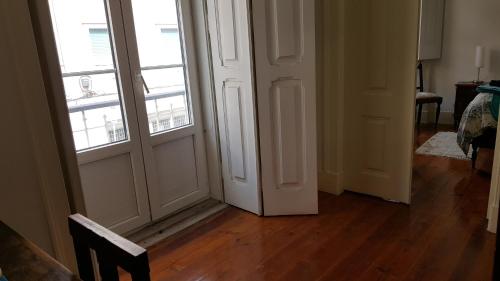 an empty room with a door and two windows at Grandmommy's House - Traditional and comfy Lisboan apartment in Lisbon