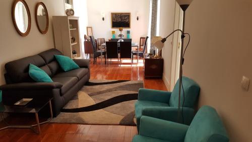 uma sala de estar com um sofá, cadeiras e uma mesa em Grandmommy's House - Traditional and comfy Lisboan apartment em Lisboa