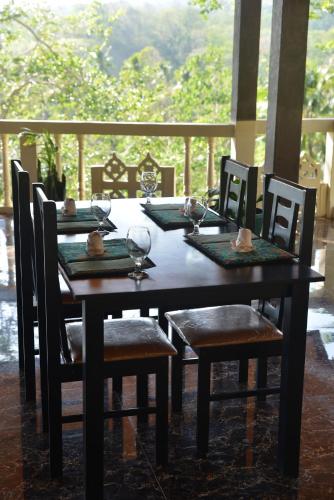 a dining room table with chairs and a table and chairsearcher at Tangkoko Sanctuary Villa in Bitung