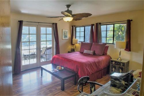 a bedroom with a bed and a ceiling fan at The Inn at Kulaniapia Falls in Hilo
