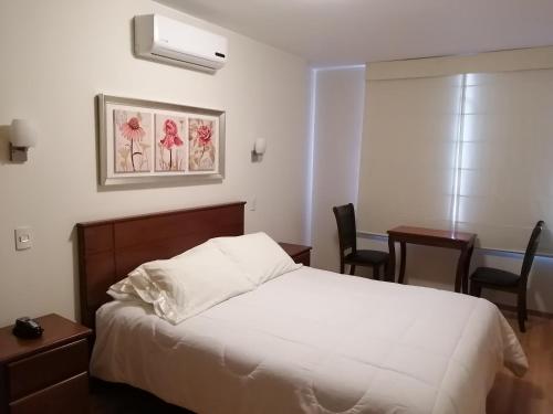 a bedroom with a bed and a table and chairs at Belle Sand Hotel in Ica