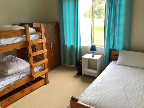 a bedroom with two bunk beds and a window at 2 Jocelyn Street. Dalmeny in Dalmeny