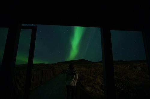 a person taking a picture of the northern lights at Drangar Country Guesthouse in Drangar