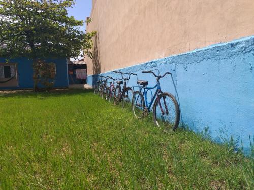 a row of bikes parked against a blue wall at Temporada no Paraíso in Ilha Comprida