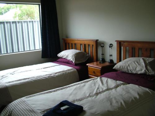 a bedroom with two beds and a window at Lawrence Townhouse Accommodation 16A in Lawrence
