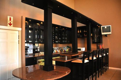 a bar with a bunch of bottles of alcohol at The Lodge at Atlantic Beach in Melkbosstrand