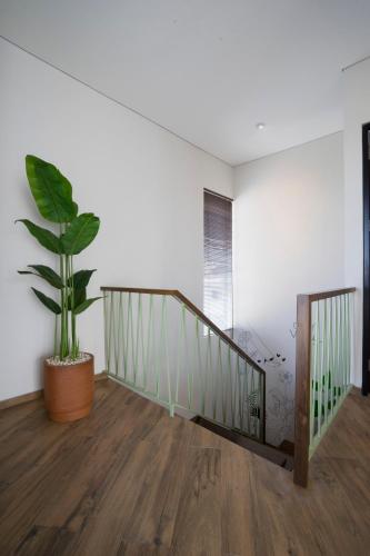 a staircase with a potted plant in a room at GAIA Lodge The Kusuma Hill Batu - Malang in Batu