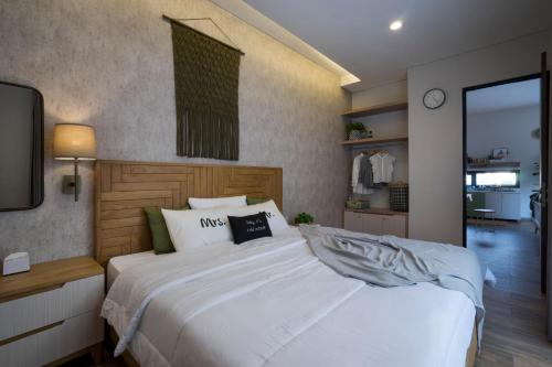a bedroom with a large white bed and a tv at GAIA Lodge The Kusuma Hill Batu - Malang in Batu