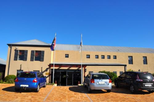 three cars parked in a parking lot in front of a building at The Lodge at Atlantic Beach in Melkbosstrand