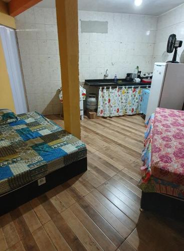 um quarto com duas camas e uma cozinha em Hospedagem Mariano em Arraial do Cabo