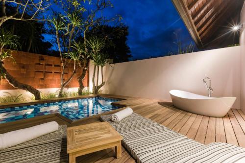 a bathroom with a bath tub and a bath tub at Downtown Villas in Seminyak