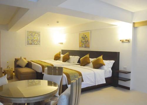 a hotel room with a large bed and a table at Commander Suites de Boracay in Boracay