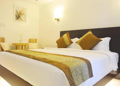 a bedroom with a large white bed with yellow pillows at Commander Suites de Boracay in Boracay