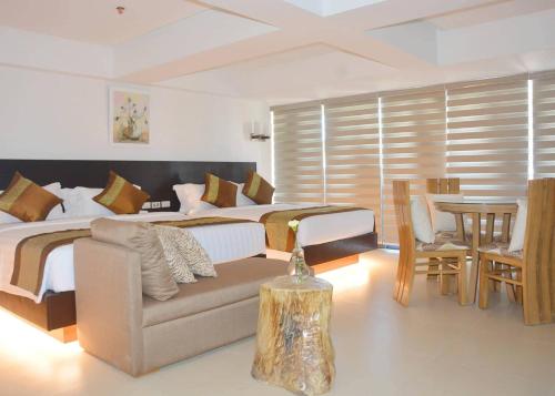 a bedroom with a bed and a couch and a table at Commander Suites de Boracay in Boracay