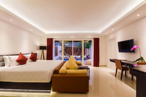 a bedroom with a large bed and a desk at Downtown Villas in Seminyak