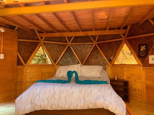 a bedroom with a bed in a wooden cabin at Glamping Los Balcones in Cuítiva