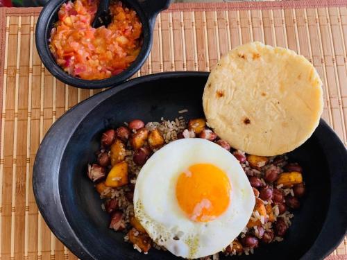 un plato de comida con huevo, judías y arroz en Glamping Los Balcones, en Cuítiva