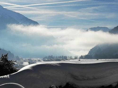 a view of a snowy field with clouds in the sky at Privathaus Achensee in Achenkirch