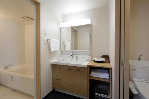 AshoroHotel REUS Ashoro的带水槽、浴缸和镜子的浴室