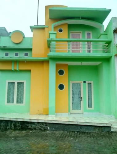 a green and orange house with a balcony at Villa Berastagi Highland No 8-i in Berastagi