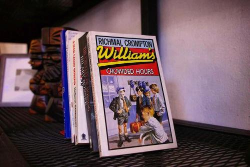 a group of books sitting on a shelf at Backpack Hostel in Chiang Rai