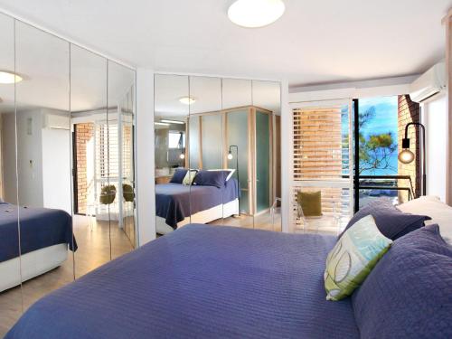 um quarto com 2 camas e uma parede espelhada em Spectacular Location and Views, 3 Bedrooms , Private Rooftop Spa em Mooloolaba