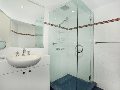 a bathroom with a sink and a glass shower at Little Hill 3 River Side 2 Bedroom Apartment across the road to the beach in Mooloolaba